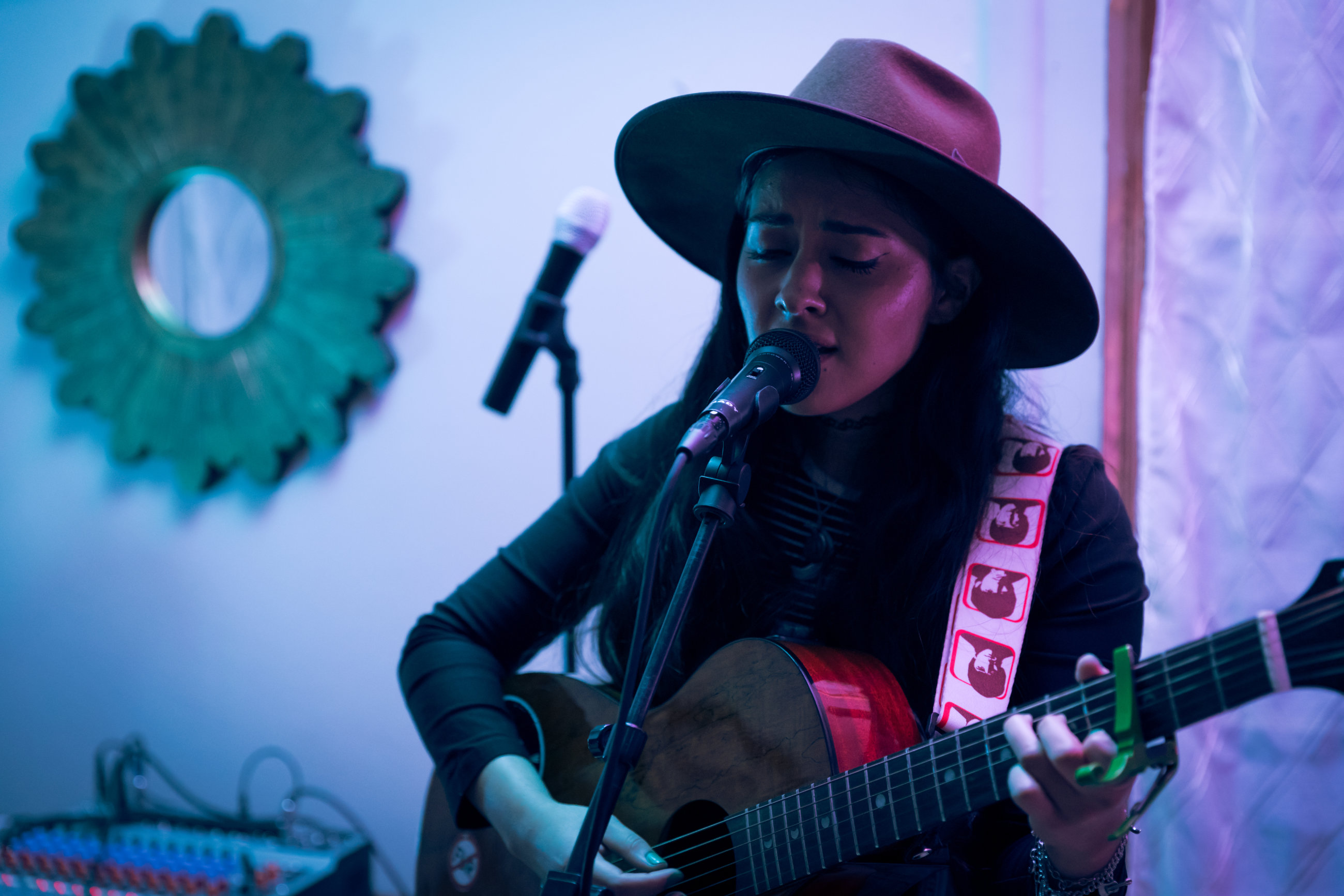 Portrait of a muscician singing and playing guitar in an aesthetic venue