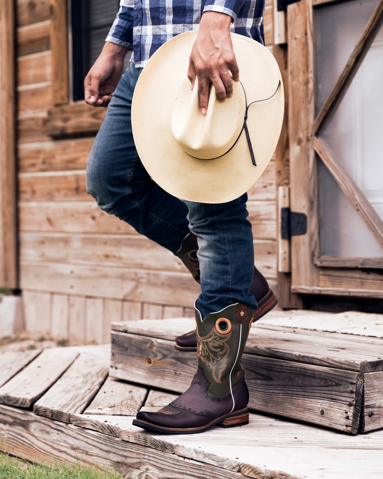 Aesthetic photo of a cowboy stepping out of a cabin with the focus on their boots